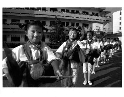 [Corps of girl drummers performing on the school basketball court before student onlookers], Yangzhou, China