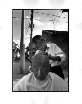 [Barber shaving man’s head], Yangzhou, China