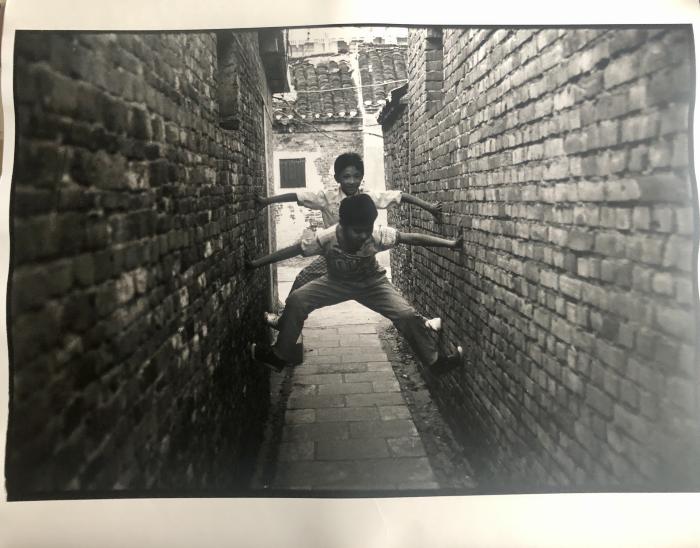 [Two boys outstretched between two buildings], Yangzhou, China