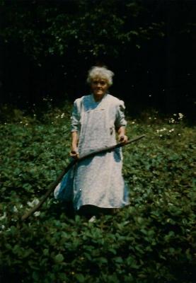 Photograph of Charcoal Annie w/ agricultural tool 