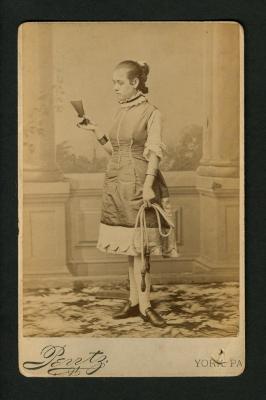 Photograph: Portrait of a young female performer, possibly Dolly Sharpe, holding skipping rope and fan