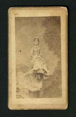 Photograph: Portrait of girl in studio sitting on a rock