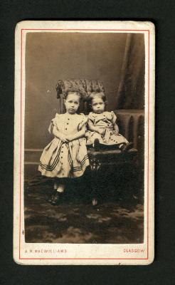 Photograph: Portrait of young girl and baby in matching dresses