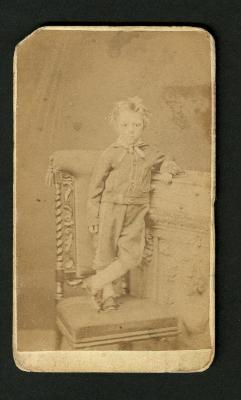 Photograph: Portrait of young boy standing on chair