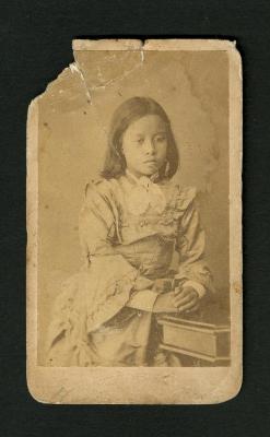 Photograph: Portrait of dark-haired girl with hands on table