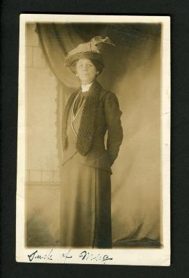 Photograph: Postcard photograph of woman in plain dark skirt suit
