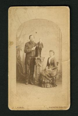 Photograph: Portrait of a man, a boy or little person, and a woman