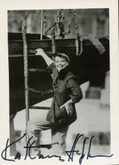 Signed photograph of Katharine Hepburn in hat with hand on ladder of a boat